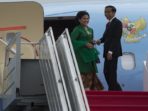 Presiden Joko Widodo (kanan) dan Ibu Negara Ny. Iriana Joko Widodo (kiri) membalikkan badanya sesaat sebelum memasuki pesawat kepresidenan di Bandara Internasional Halim Perdanakusumah, Jakarta